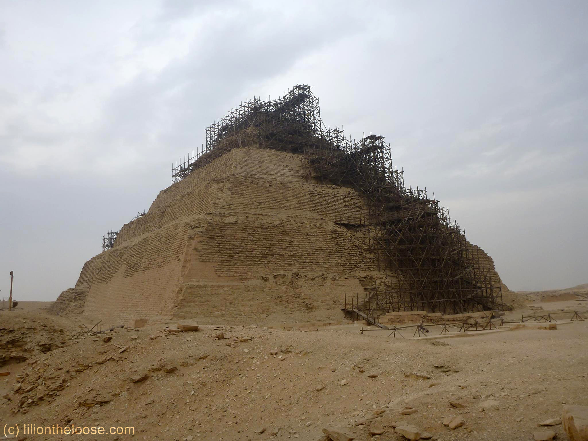 Scaffolding on the Step Pyramid, with a lonely single worker hammering away.